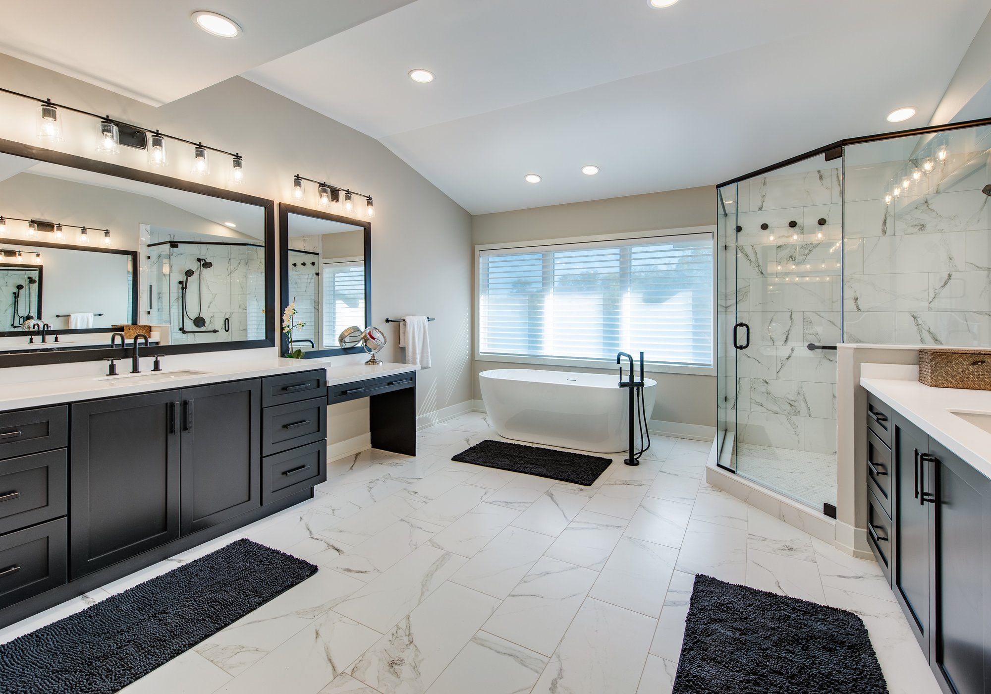 Primary bathroom remodel with white quartz, dark cabinets, a soaking tub, and glass-walled walk-in shower