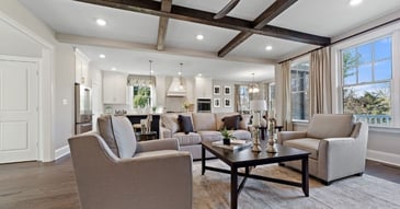 Open-concept living room with exposed wood beams and modern furniture, Thompson Communities remodel, West Chester, PA