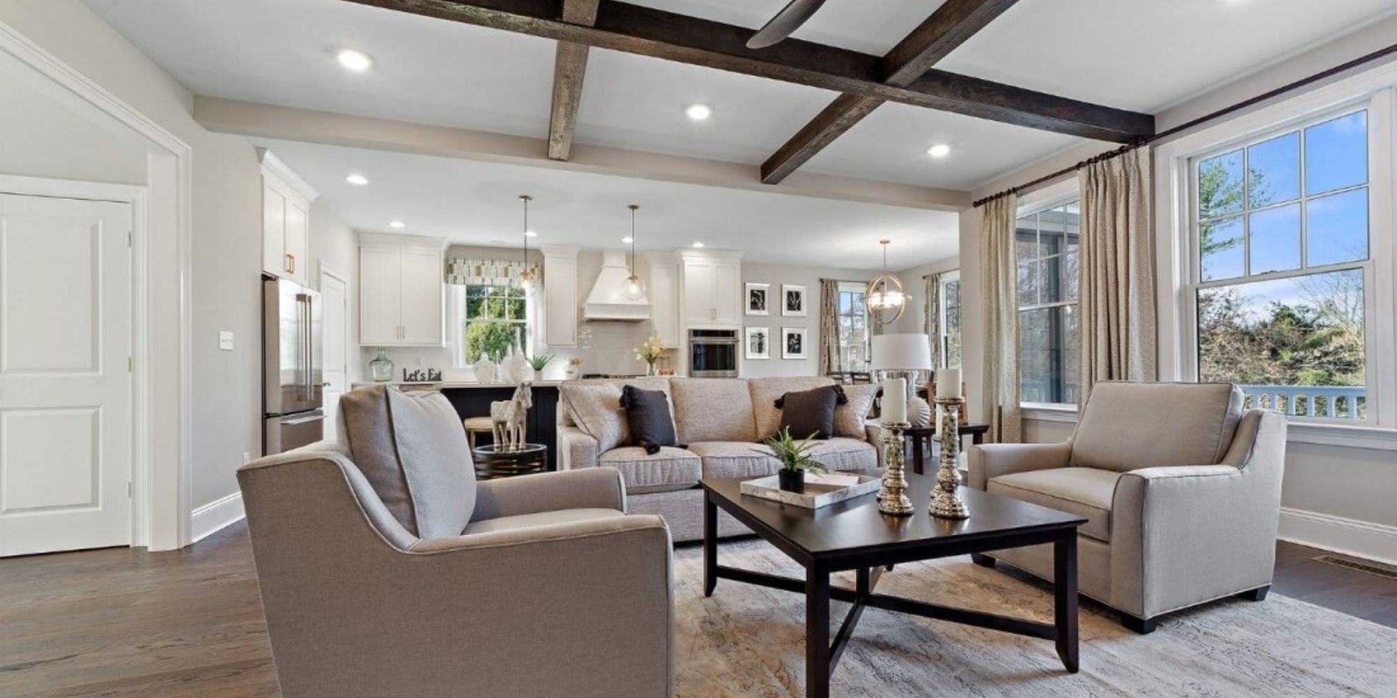 Open-concept living room with exposed wood beams and modern furniture, Thompson Communities remodel, West Chester, PA
