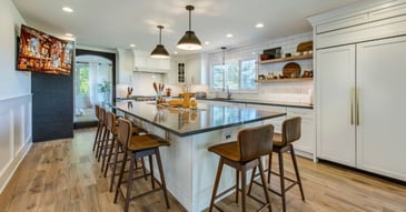 Remodeled kitchen with island seating, hidden fridge by Thompson Communities