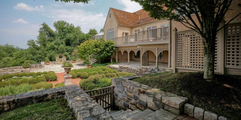 Image of custom home hardscaping with stone retaining walls and patio in West Chester, PA by Thompson Communities