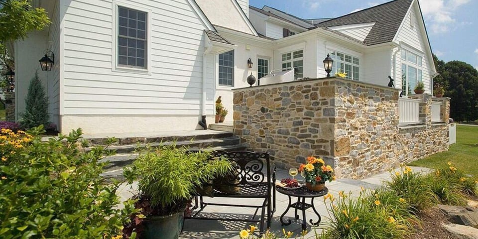 Back patio design with retaining wall and garden by Thompson Communities Custom Homes