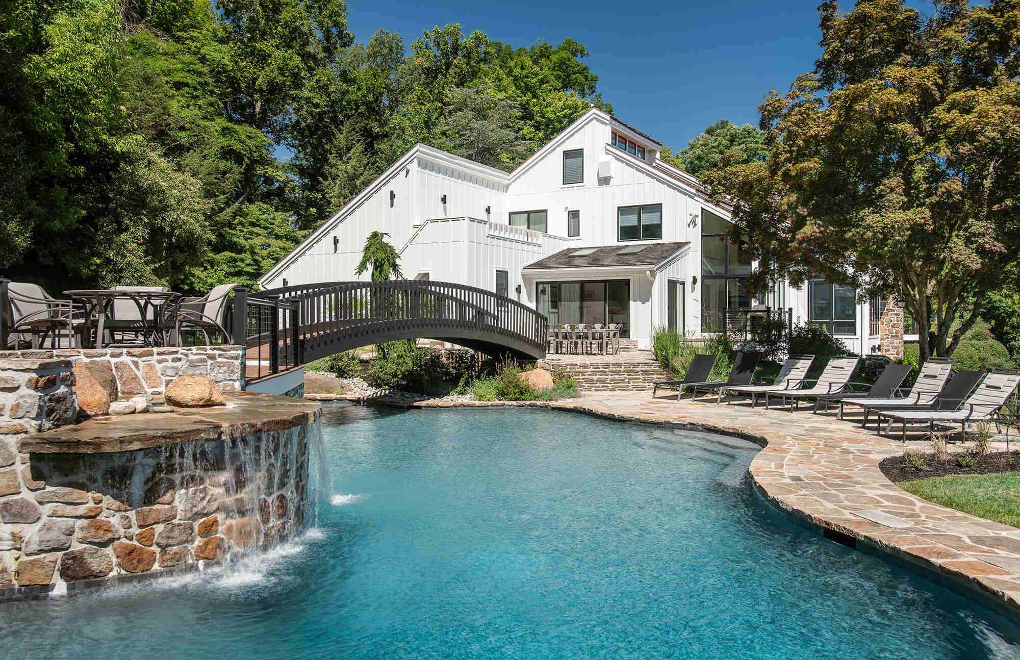 Stunning backyard view with a pool and waterfall feature, Thompson Communities whole-house makeover, Berwyn, PA