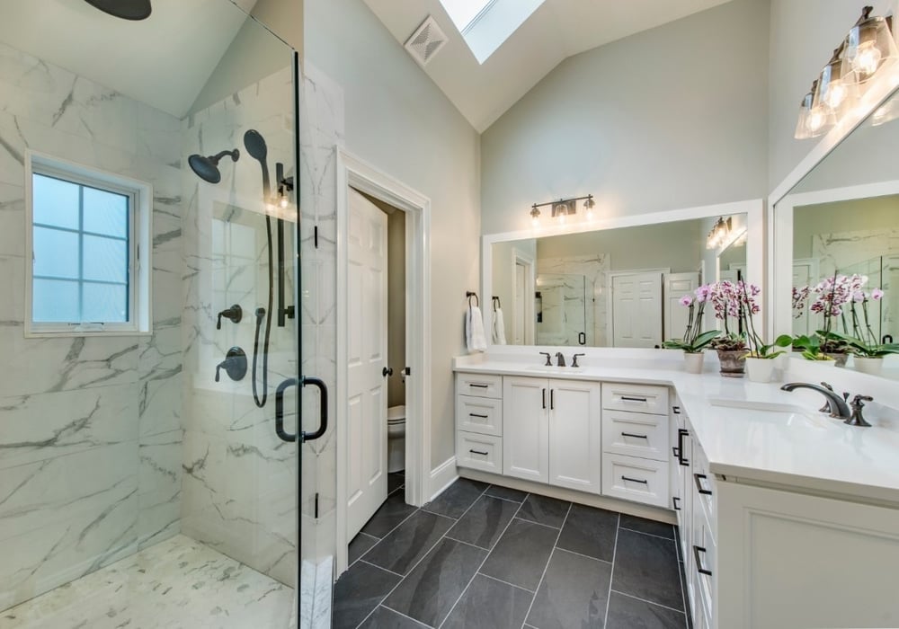 Modern bathroom with marble shower and dual vanity in a West Chester, PA home addition by Thompson Communities