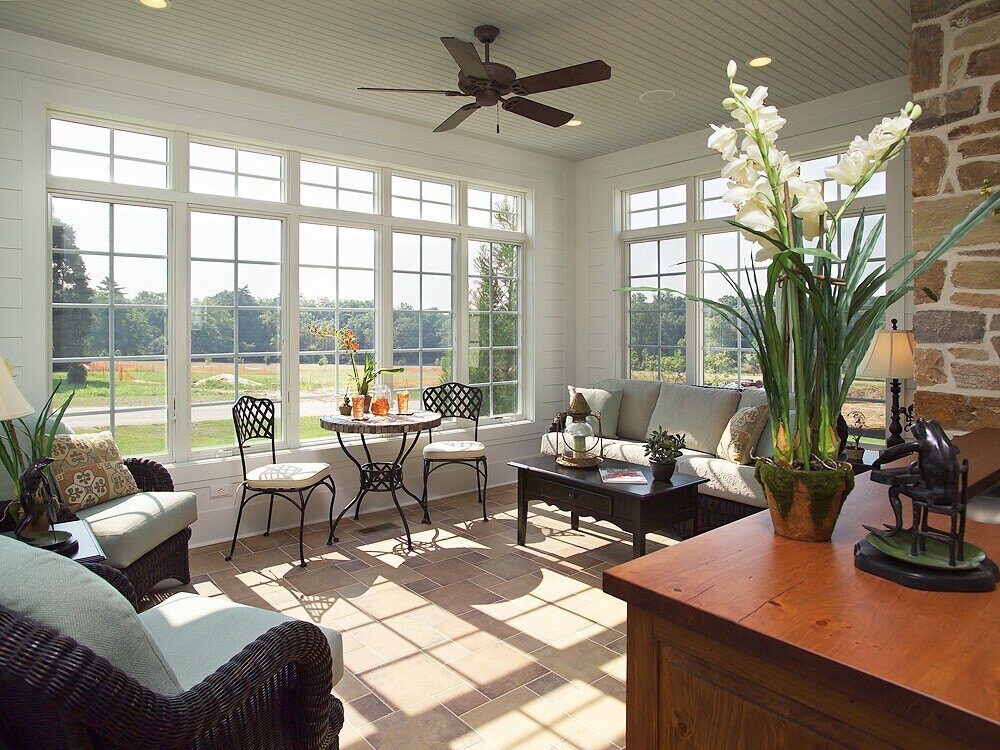 Sunroom addition with wicker furniture and expansive windows in West Chester, PA by Thompson Communities