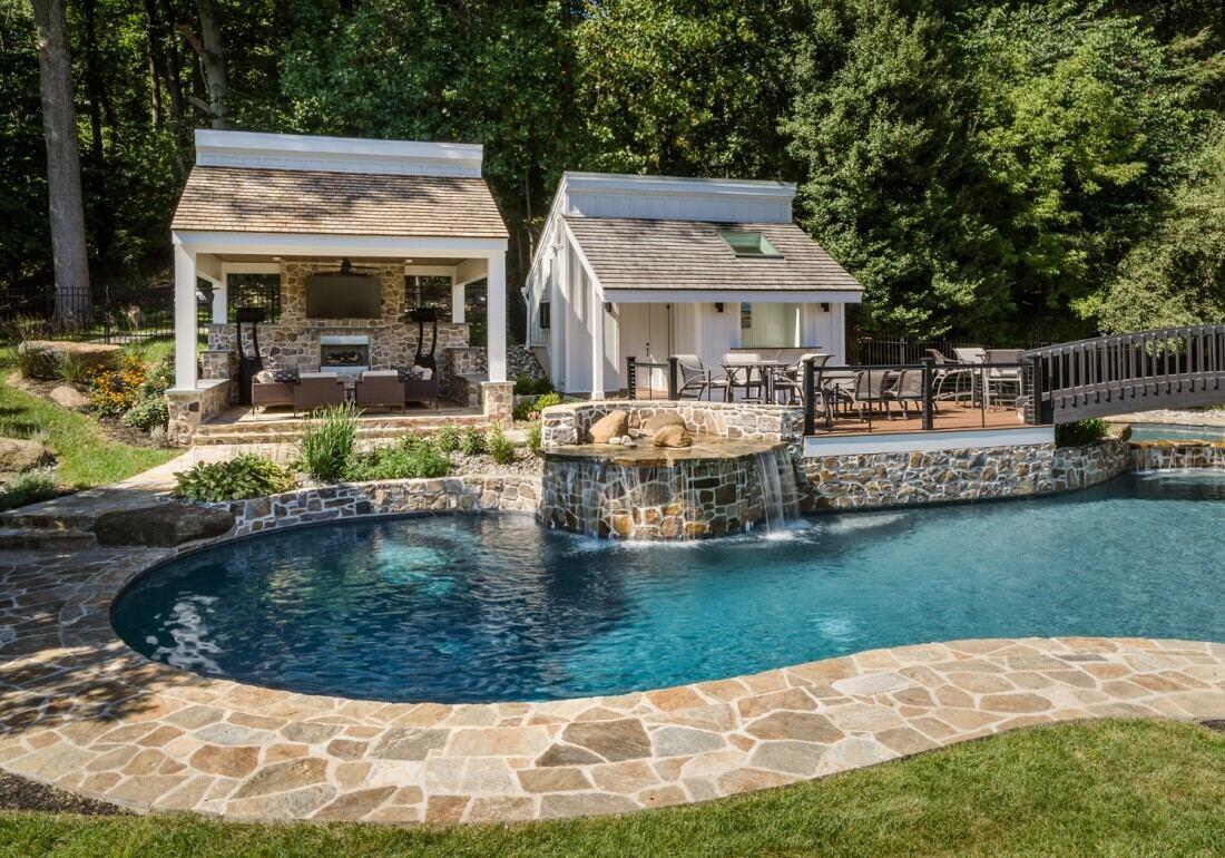 Backyard oasis in West Chester, PA, featuring a custom pool and outdoor living area by Thompson Communities