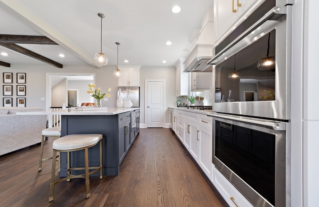 Bright and airy kitchen with dark island cabinetry in a custom home by Thompson Communities, West Chester, PA