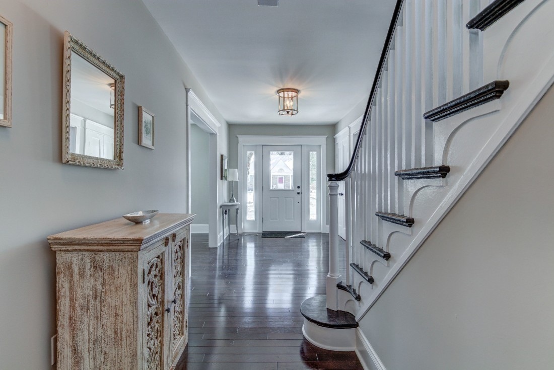 Bright and welcoming foyer with a curved staircase and modern lighting, Thompson Communities remodel, West Chester, PA