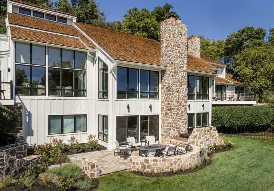 Spacious backyard with stone patio and outdoor fireplace, part of a Thompson Communities remodel in West Chester, PA