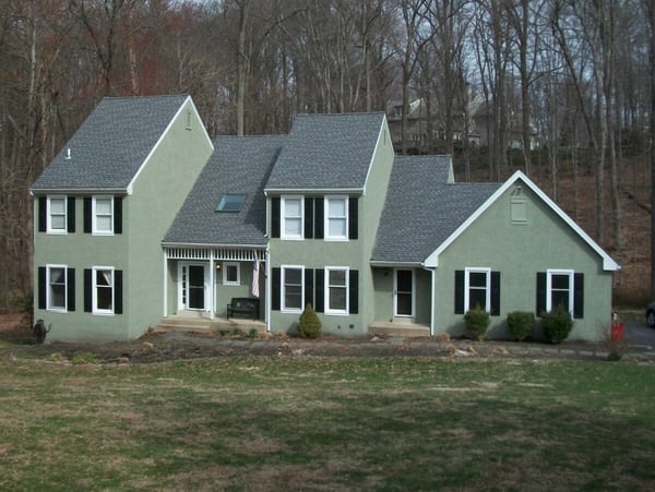 Home Exterior with Green Stucco Before Remediation and Siding Installation by Thompson Communities in West Chester, PA