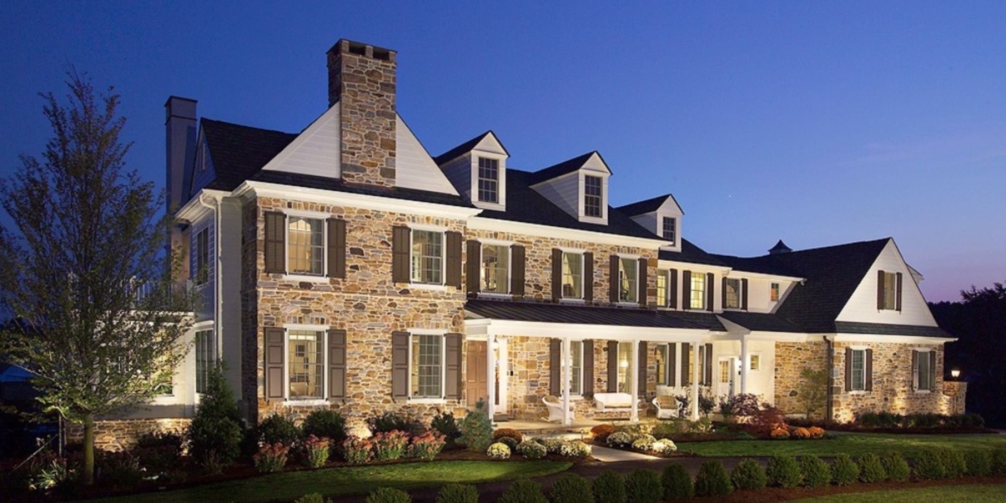 Custom Home built in West Chester with a stone facade, dormer windows, and landscaping by Thompson Communities