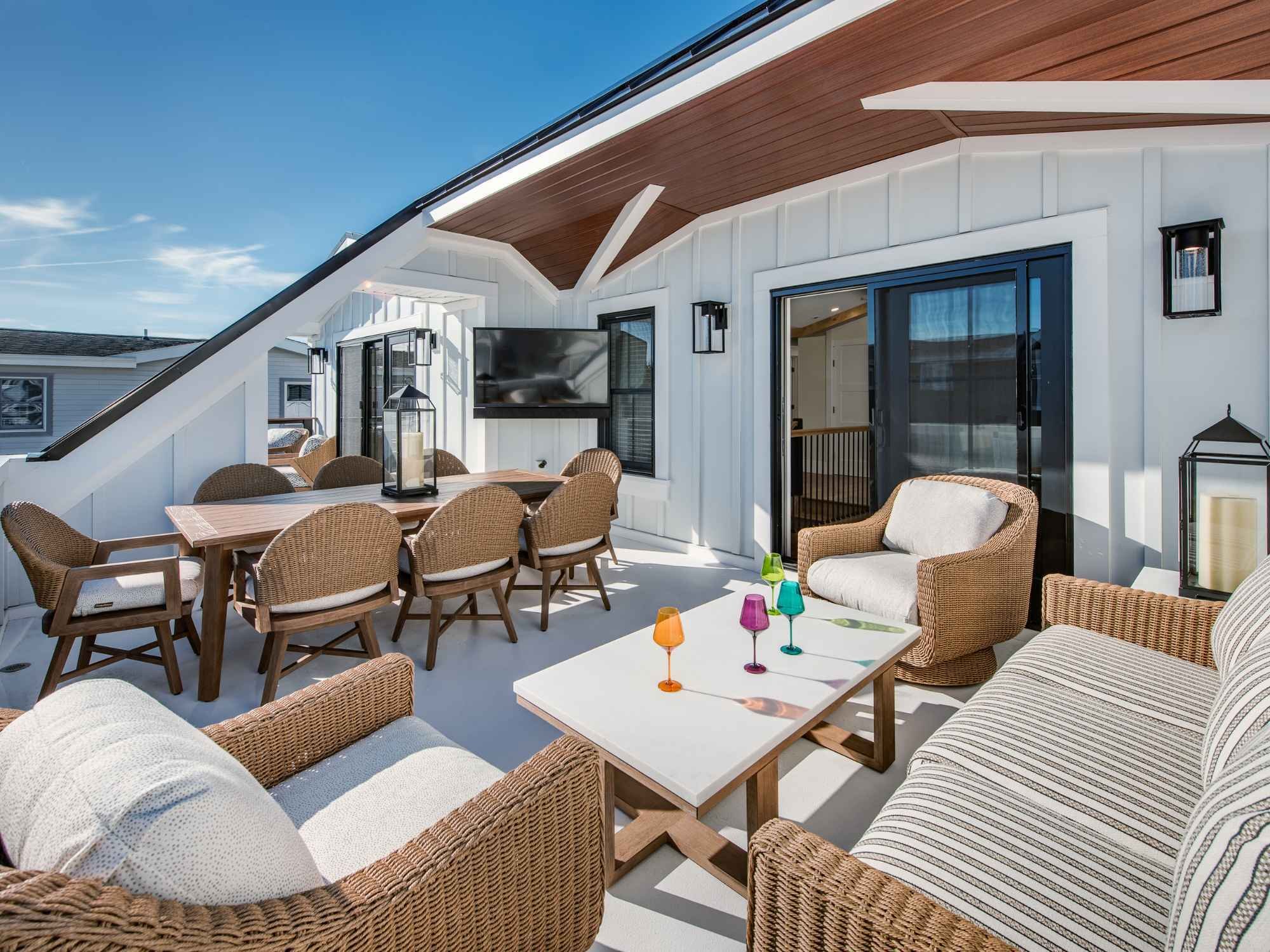 A rooftop deck in a custom home with dining and seating areas by Thompson Communities in Avalon A rooftop deck in a custom home with dining and seating areas by Thompson Communities in Avalon