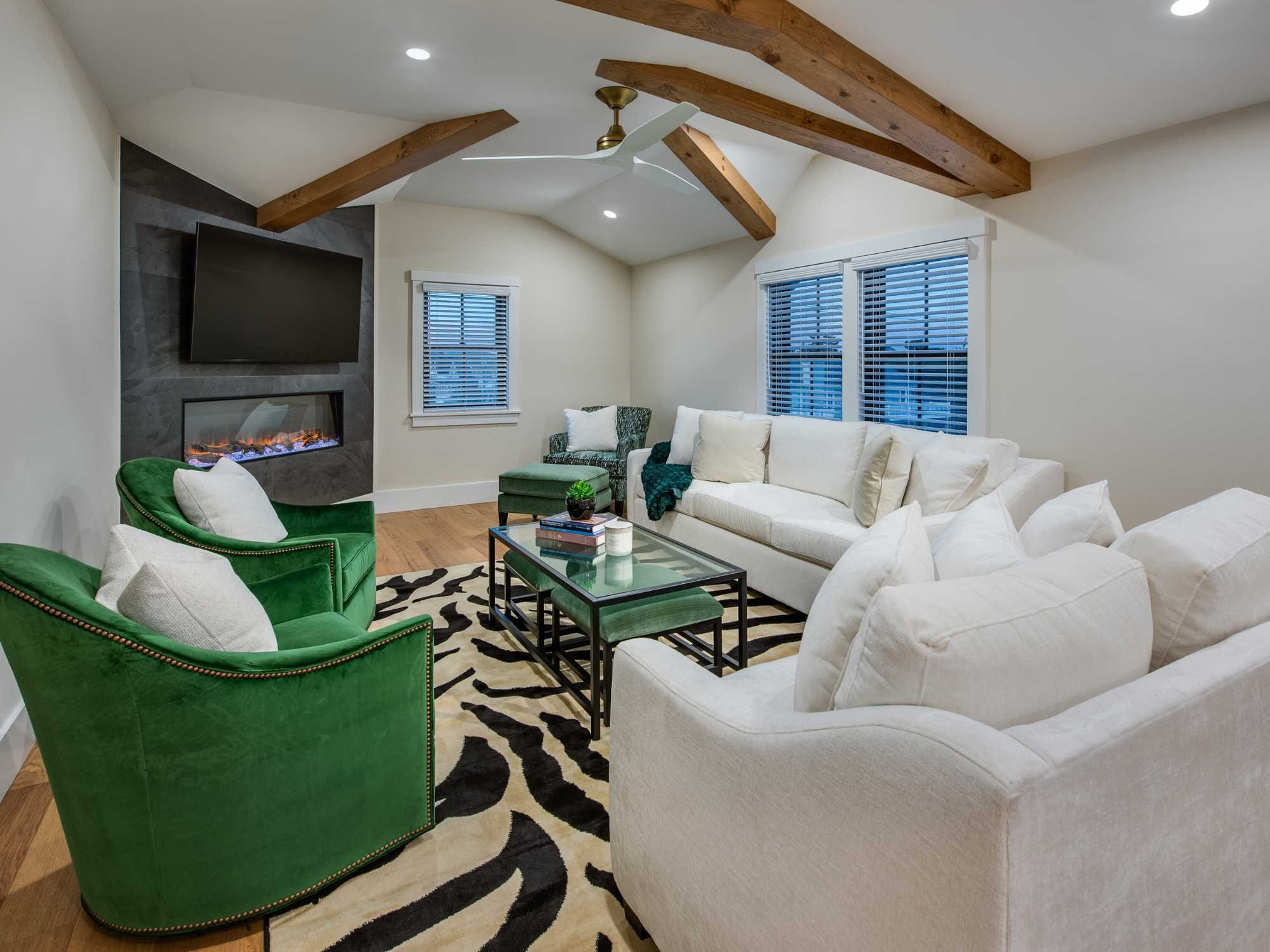 A great room on the third floor of a custom home with exposed beams by Thompson Communities in Avalon A great room on the third floor of a custom home with exposed beams by Thompson Communities in Avalon