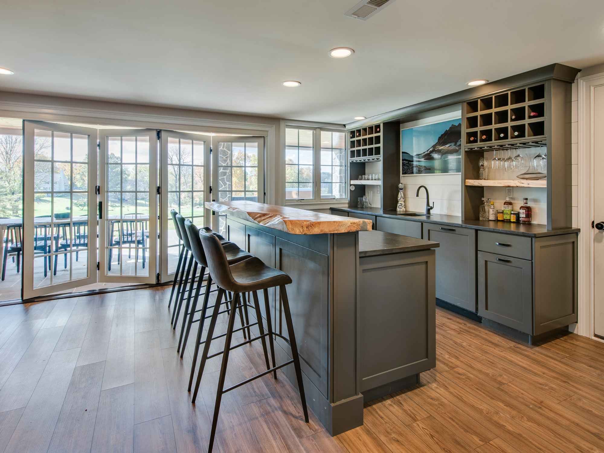 Elegant home bar remodel by Thompson Communities in West Chester, PA, featuring a live-edge countertop, custom wine storage, and indoor-outdoor connection