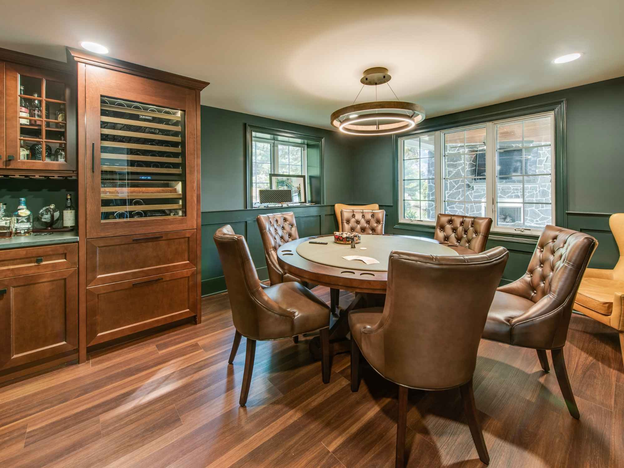 Elegant poker room with leather chairs and custom round table in West Chester, PA by Thompson Communities