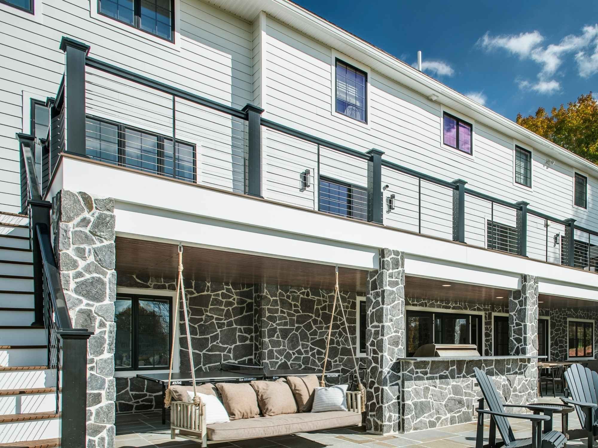Exterior modern farmhouse whole home remodel with a large deck and white siding in West Chester, PA by Thompson Communities