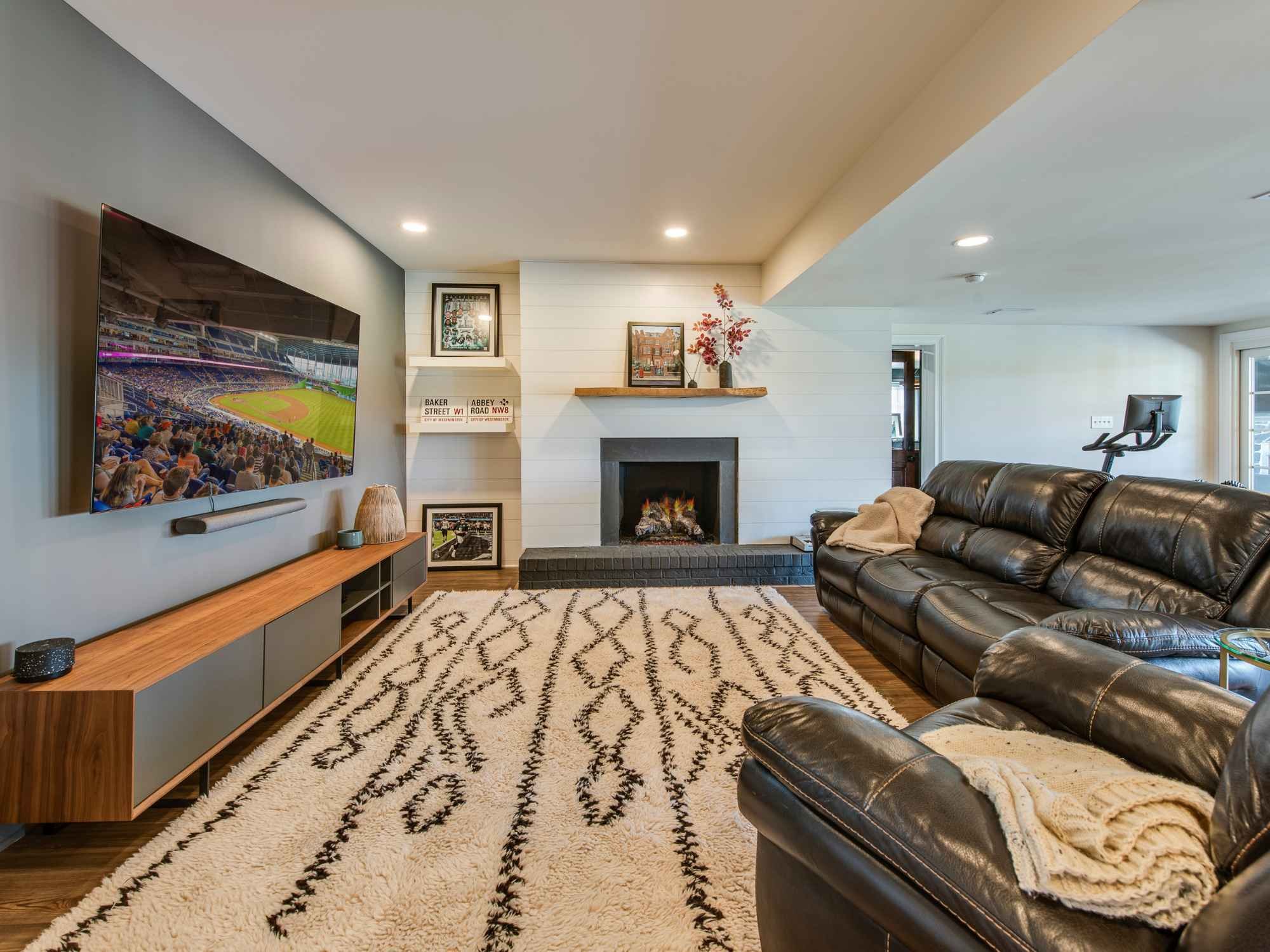 Modern family room with built-in shelves, black brick fireplace, and large screen TV by Thompson Communities in West Chester, PA Modern family room with built-in shelves, black brick fireplace, and large screen TV by Thompson Communities in West Chester, PA