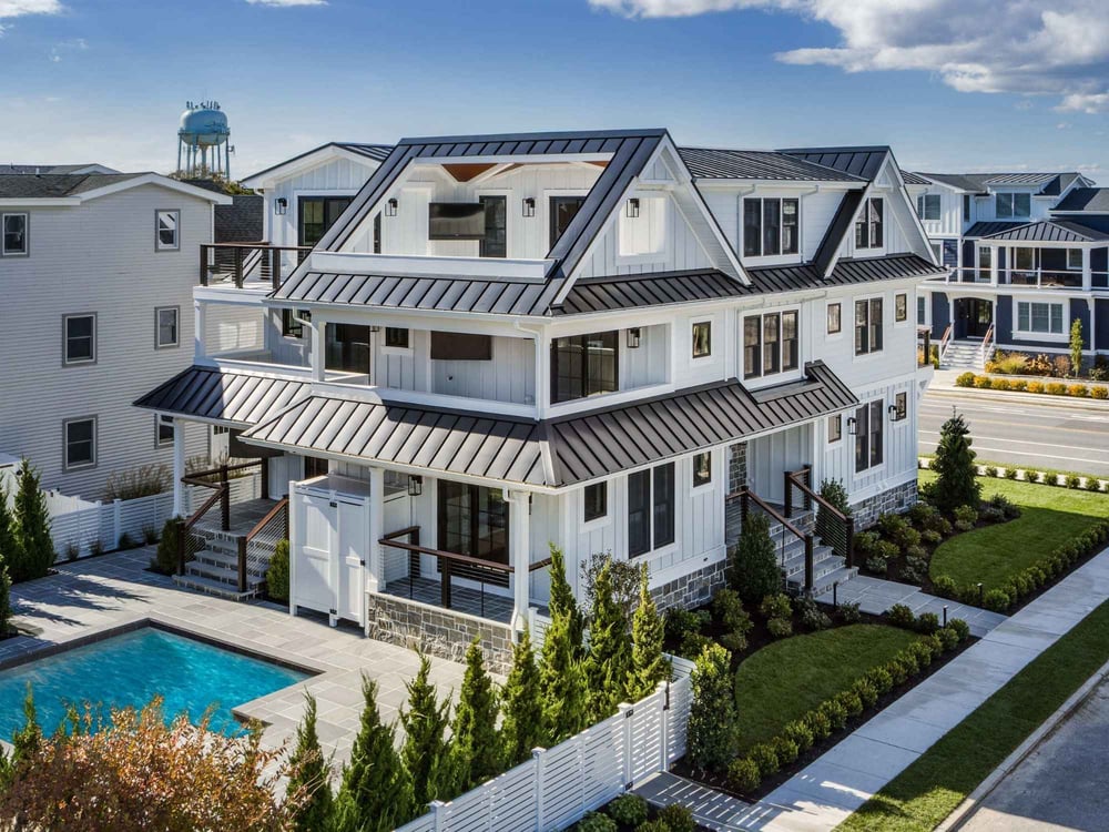 Drone photo of a custom home with a pool and multiple decks on every level by Thompson Communities in Avalon, NJ