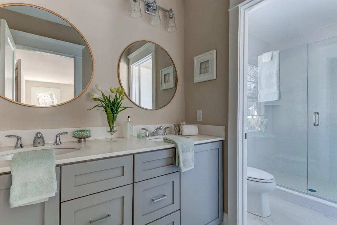 Elegant double vanity bathroom with round mirrors and modern fixtures, remodeled by Thompson Communities, West Chester, PA (1)