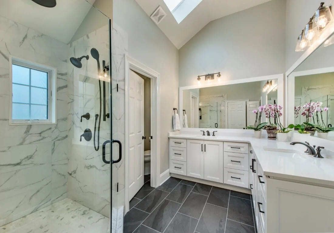 Spacious bathroom with a glass shower and double vanity, part of a remodel by Thompson Communities in West Chester, PA